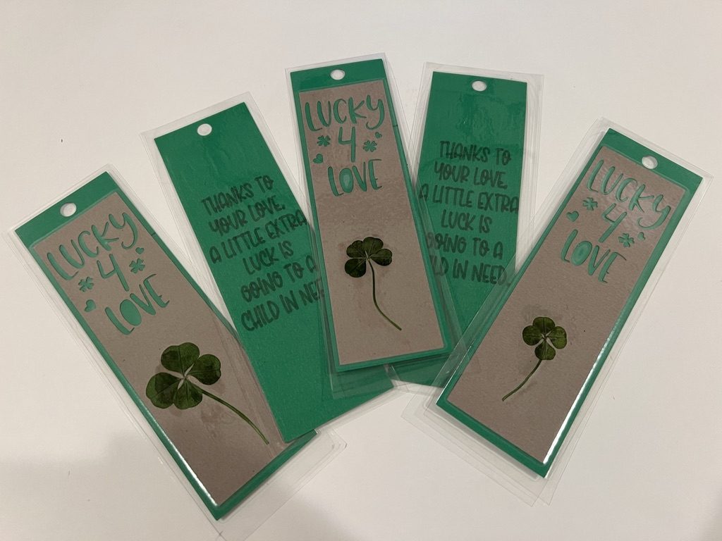 A handmade Lucky4Love bookmark holding a real four-leaf clover and a pink paper heart